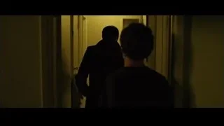 two men in dimly lit hallway — The Social Network