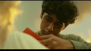 Young man intently looking at red object outdoors — Life of Pi
