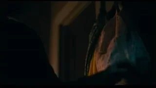 Person in dimly lit room with clothes rack — Joker