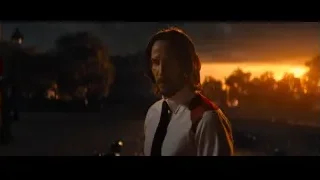 man with long hair in red vest cityscape — John Wick: Chapter 4