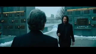 two men at stone wall with gun — John Wick: Chapter 4