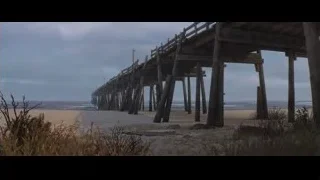 long wooden pier extending into ocean — Cars 3