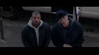 two men standing on a street — Creed