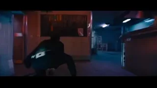 man holding gun in dimly lit bar — John Wick: Chapter 4