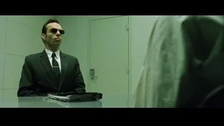 man in suit and sunglasses at desk — The Matrix
