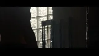 person standing by large grid window — Southpaw