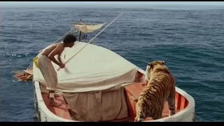 Man on small boat with tiger in ocean — Life of Pi