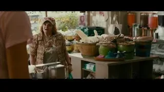 woman standing at store counter with items — The Dictator