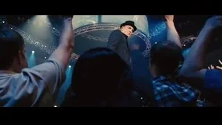man on stage with raised arms — Now You See Me