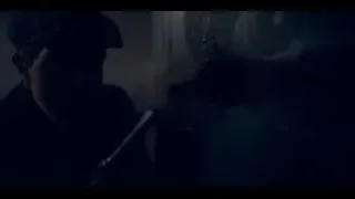 man in cap holding microphone in dark room — Peaky Blinders