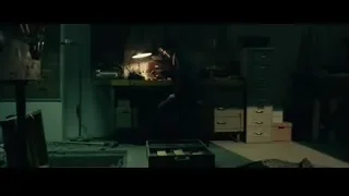 Man sitting at desk in dark cluttered room — John Wick