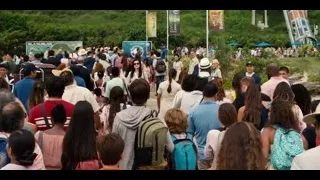 large crowd gathered in park with Ferris wheel — Jurassic World