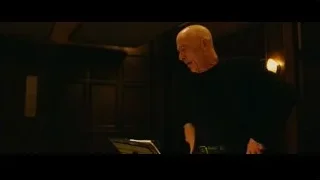 Bald man standing deep in thought in dimly lit room — Whiplash