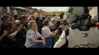 race car driver embracing woman in pit lane — F1
