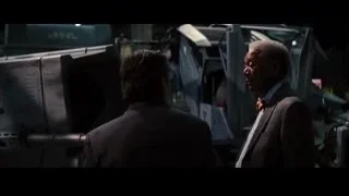 two men in suits by large machine — Batman: The Dark Knight Rises