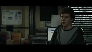 Young man sitting at desk with computer — The Social Network