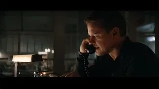 man talking on phone at dimly lit desk — Ford v Ferrari