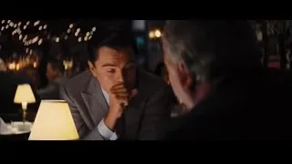 two men conversing in dimly lit restaurant — The Wolf Of Wall Street