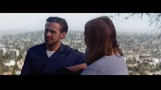 man gesturing to woman overlooking city — La La Land