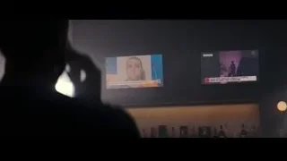 person in front of screens with man's portrait — Creed 3