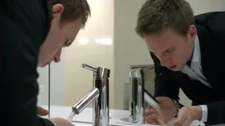 two men in bathroom by sink — Suits