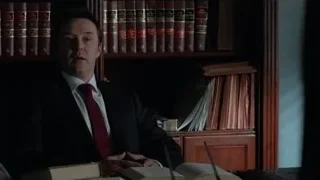 man in suit sitting at office desk — Suits