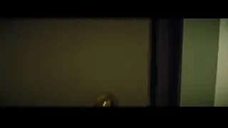 young woman looking out window in dim room — La La Land
