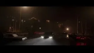 black car driving on wet street at night — Creed 3