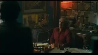 man sitting at desk in cluttered room — Joker