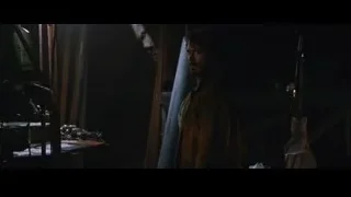 man standing in a dimly lit room with a desk — Iron Man