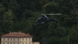 Black helicopter flying over houses — Succession