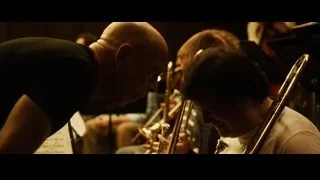 Musicians playing instruments in dimly lit room — Whiplash