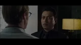 Two men in suits conversing in dimly lit room — The Amazing Spider Man