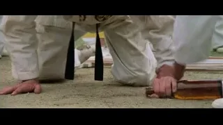 man kneeling picking up wooden object — Bruce Lee: Enter The Dragon