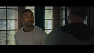 two men conversing by window — Creed 2