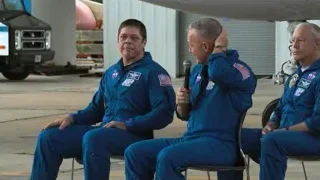 three men in space suits sitting by airplane — Elon Musk: Return to Space