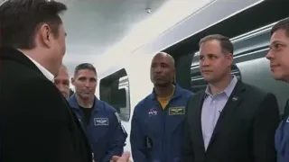men in space suits conversing in train — Elon Musk: Return to Space