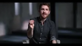 Man with beard gesturing seriously in dark room — The Social Dilemma