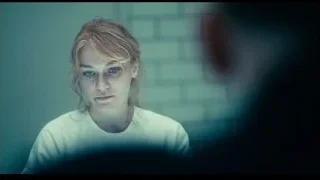 young man looking at camera in dim room — Joker