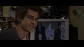 man looking at computer monitor with photos — The Amazing Spider Man