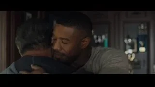 Two men conversing in dimly lit room — Creed 2