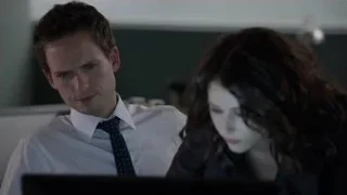 Man and woman looking at computer in office — Suits