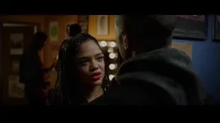 Woman looking at man in dimly lit room — Creed