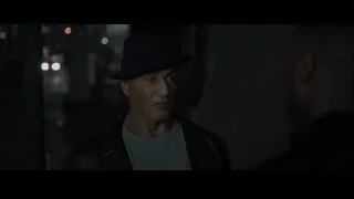 Man in black hat on city street at night — Creed 2