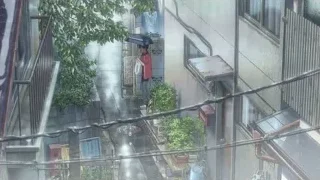 Person with umbrella in narrow urban alleyway — Weathering with You