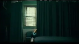 man sitting in chair looking out window — Joker