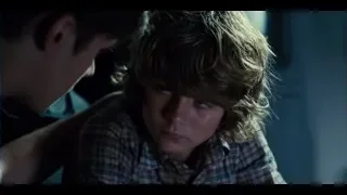 Man comforting sad boy in dim room — Jurassic World