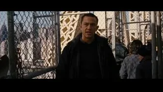 man standing in front of chain-link fence — Batman: The Dark Knight Rises