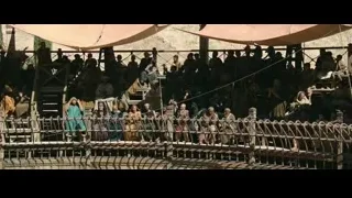 People gathered on wooden bridge with tents — Gladiator 2