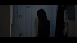 Woman looking out white door — Creed